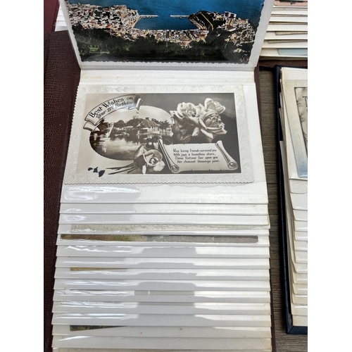 396 - Four albums containing a large collection of antique and vintage postcards to include silk, birthday... 