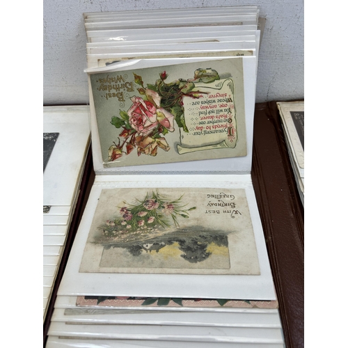 396 - Four albums containing a large collection of antique and vintage postcards to include silk, birthday... 