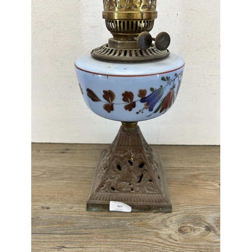 407 - A late 19th/early 20th century National Works cast iron and hand painted glass oil lamp with clear g... 