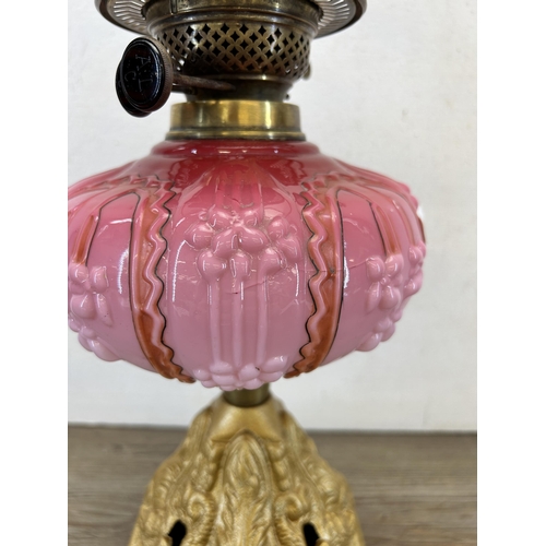 410 - A late 19th/early 20th century A. L. C. gilt metal and pink glass oil lamp with clear glass funnel -... 