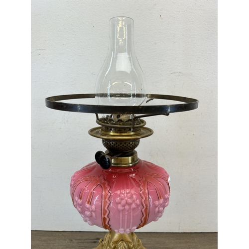 410 - A late 19th/early 20th century A. L. C. gilt metal and pink glass oil lamp with clear glass funnel -... 