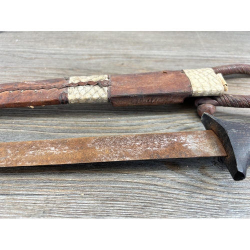 458 - A vintage ethnographical dagger with carved hardwood handle and leather sheath - approx. 39cm long