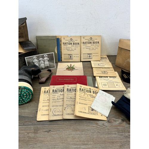 404 - A collection of militaria to include two gas masks, Ministry of Food ration books etc.