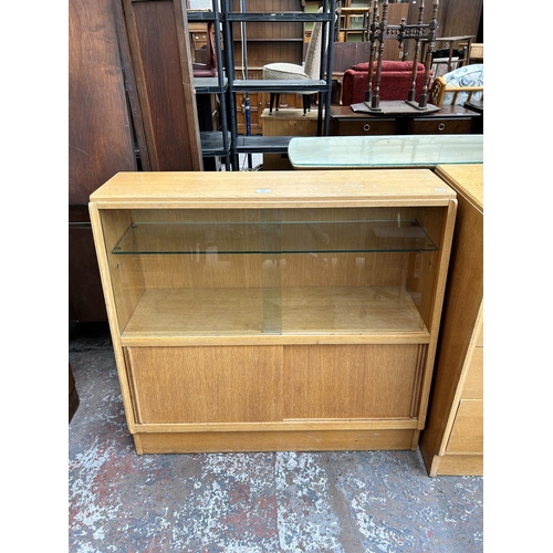 104 - A 1950s G Plan Brandon oak bookcase with two glass sliding doors and two lower cupboard doors - appr... 