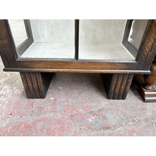 107 - An Art Deco oak bookcase with single glazed door and two internal glass shelves