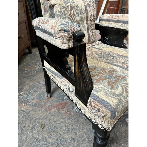 11 - An Edwardian ebonised and fabric upholstered armchair