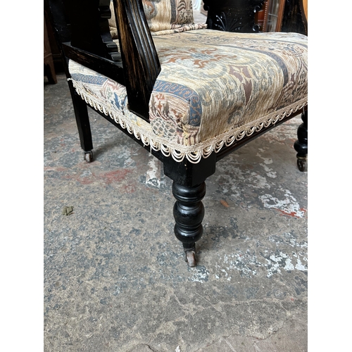 11 - An Edwardian ebonised and fabric upholstered armchair