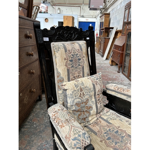 11 - An Edwardian ebonised and fabric upholstered armchair