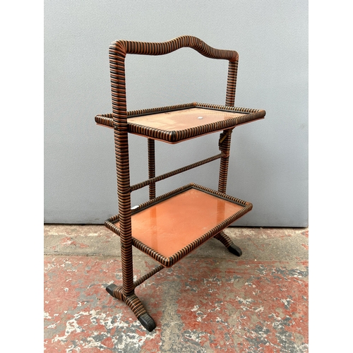 141 - A mid 20th century orange and black painted wicker and glass two tier folding side table