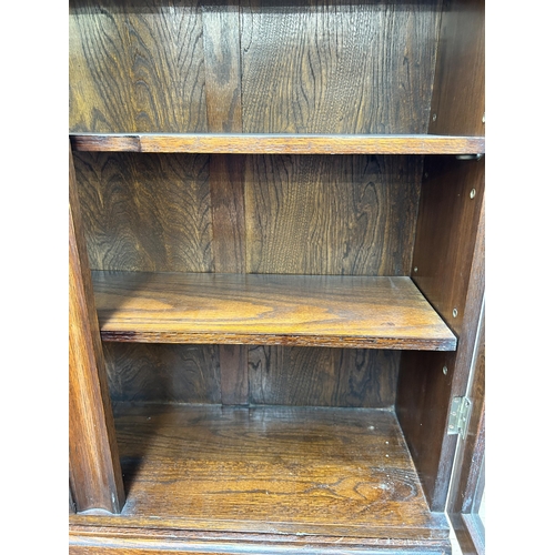 148 - An Art Deco style oak bureau bookcase with two upper glazed doors, fall front, three drawers and bal... 