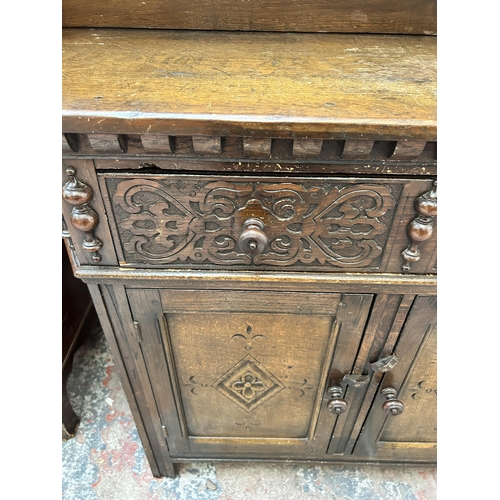 16 - A 17th century style carved oak dresser with upper plate rack, single drawer and two lower cupboard ... 