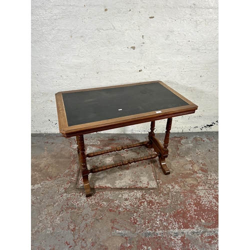 176 - A Victorian walnut writing table with black writing surface