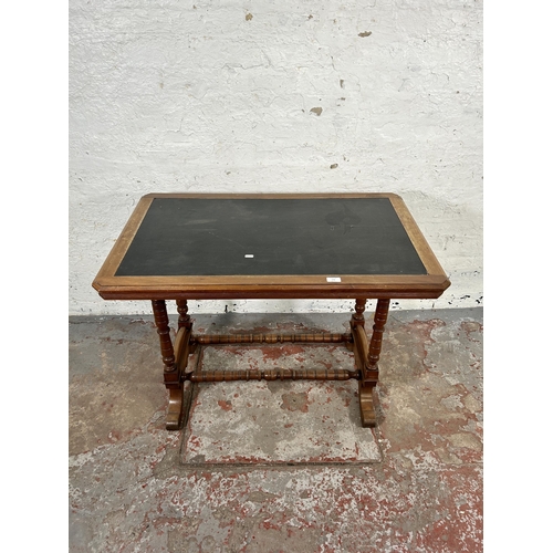 176 - A Victorian walnut writing table with black writing surface