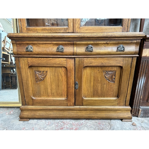 23 - An Arts & Crafts carved oak bookcase - approx. 208cm high x 122cm wide x 47cm deep