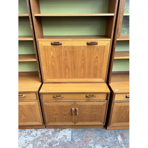 31 - A 1970s G Plan teak cocktail cabinet/bookcase with fall front, single drawer and two cupboard doors ... 