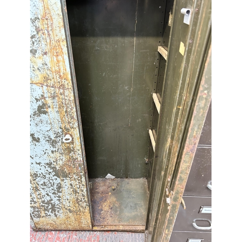 69 - A mid 20th century painted military green metal two door industrial cabinet