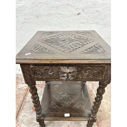 70 - A Victorian carved oak two tier side table with green man design and barley twist supports - approx.... 