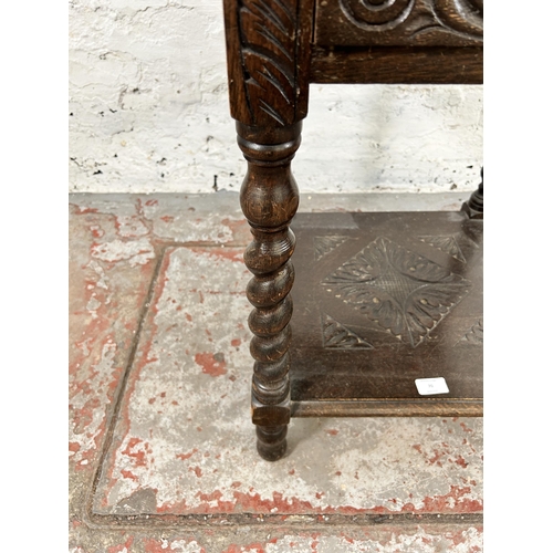 70 - A Victorian carved oak two tier side table with green man design and barley twist supports - approx.... 