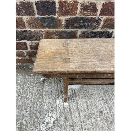 79 - An early 20th century oak bench - approx. 48cm high x 25cm wide x 244cm long