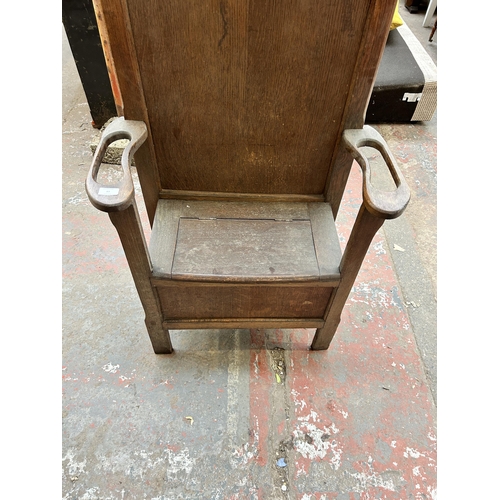 83 - A mid 20th century oak hall stand with lidded seat, central bevelled edge mirror and six coat hooks