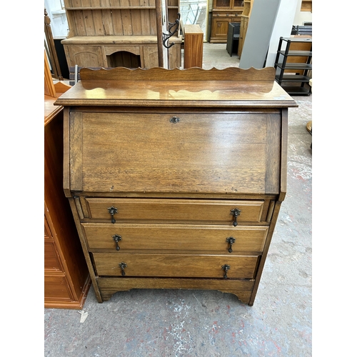 84 - An early 20th century walnut bureau with three drawers and fall front