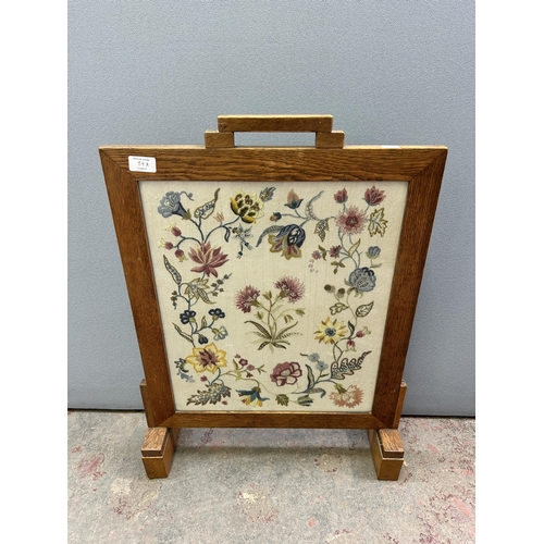 84A - An early/mid 20th century oak framed embroidered fire screen - approx. 75cm high x 52cm wide