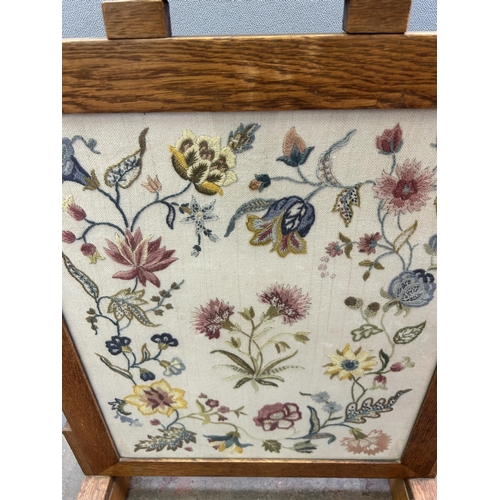 84A - An early/mid 20th century oak framed embroidered fire screen - approx. 75cm high x 52cm wide