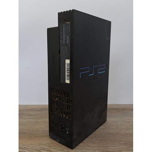 631 - A box containing a Sony PlayStation 2, games and accessories