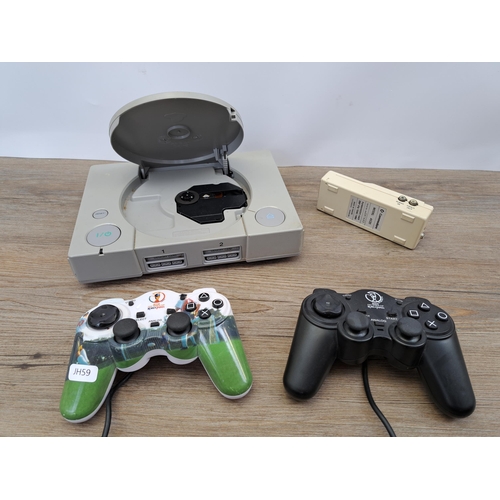 633 - A box containing two 2002 FIFA world cup Korea/Japan PlayStation controllers, Sony PlayStation 1 con... 