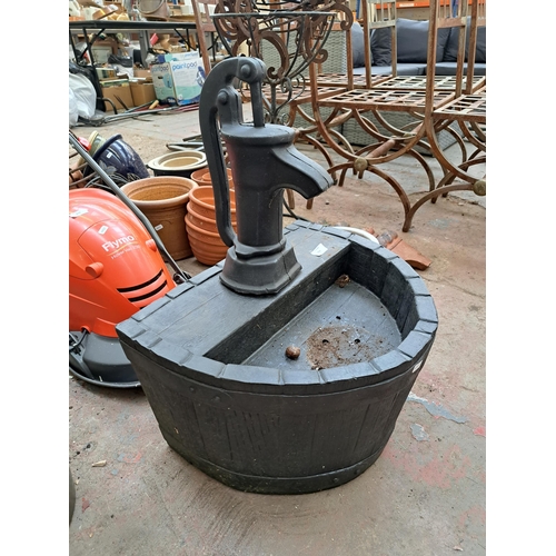 818 - A 19th century style black painted fibreglass garden water feature in the form of a water pump and b... 