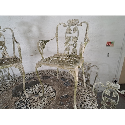 822 - A Victorian style cast metal seven piece garden patio set comprising six chairs and table decorated ... 