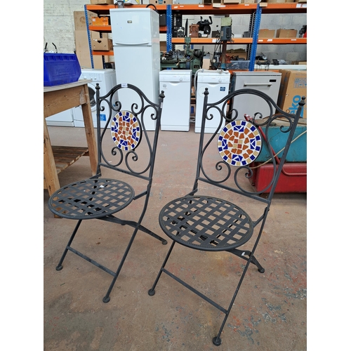 825 - A pair of wrought metal and mosaic folding patio chairs