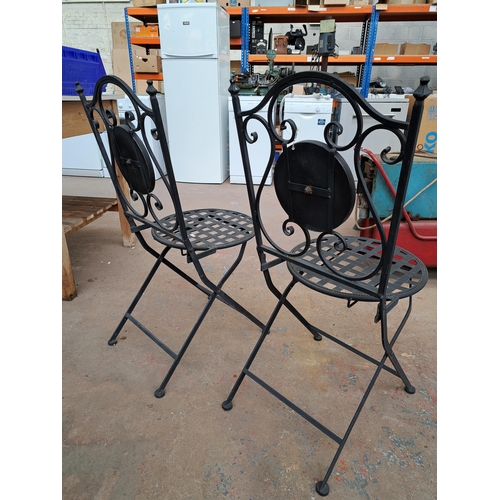 825 - A pair of wrought metal and mosaic folding patio chairs