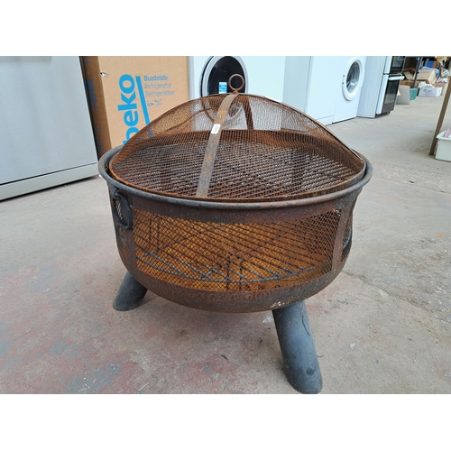 827 - A cast metal circular and tri-footed fire pit -approx. 60cm high x 62cm diameter