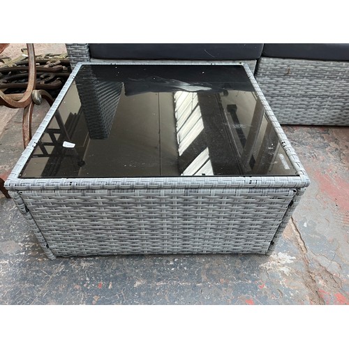 814 - A rattan effect L shaped garden sofa with tempered glass topped side table - approx. 67cm high x 204... 