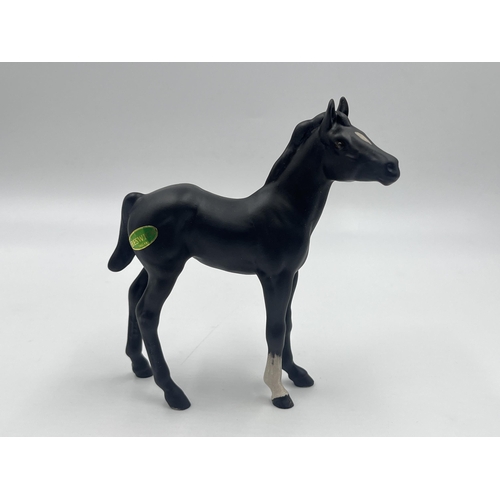 261 - Two matte black ceramic horse figurines, one Royal Doulton Spirit of Freedom on wooden plinth and on... 