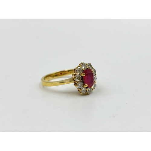 2172A - An 18ct gold ruby and diamond halo ring with paper guarantee stating estimated diamond weight 0.75ct... 