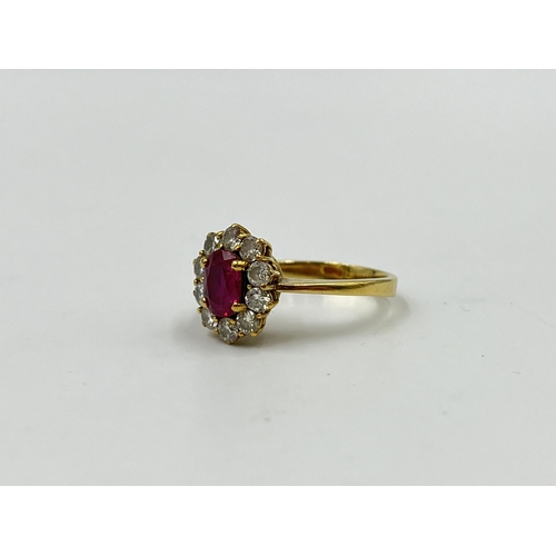 2172A - An 18ct gold ruby and diamond halo ring with paper guarantee stating estimated diamond weight 0.75ct... 