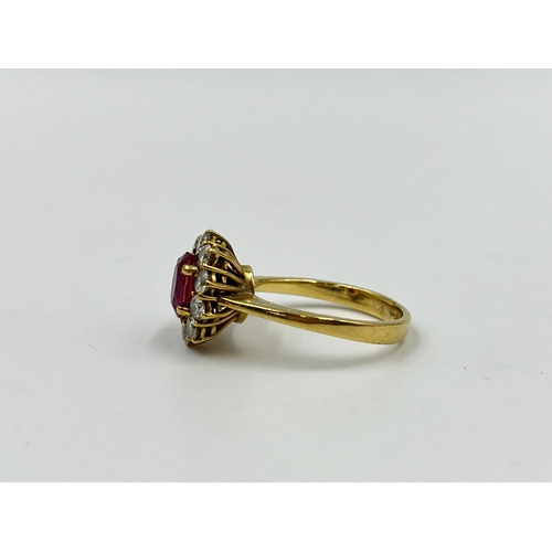 2172A - An 18ct gold ruby and diamond halo ring with paper guarantee stating estimated diamond weight 0.75ct... 