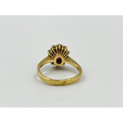 2172A - An 18ct gold ruby and diamond halo ring with paper guarantee stating estimated diamond weight 0.75ct... 