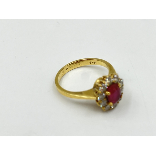 2172A - An 18ct gold ruby and diamond halo ring with paper guarantee stating estimated diamond weight 0.75ct... 