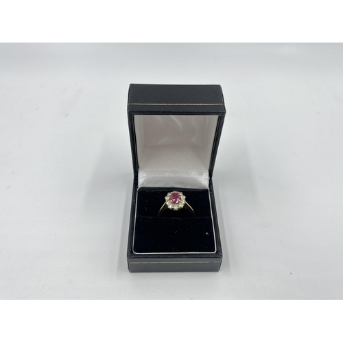 2172A - An 18ct gold ruby and diamond halo ring with paper guarantee stating estimated diamond weight 0.75ct... 