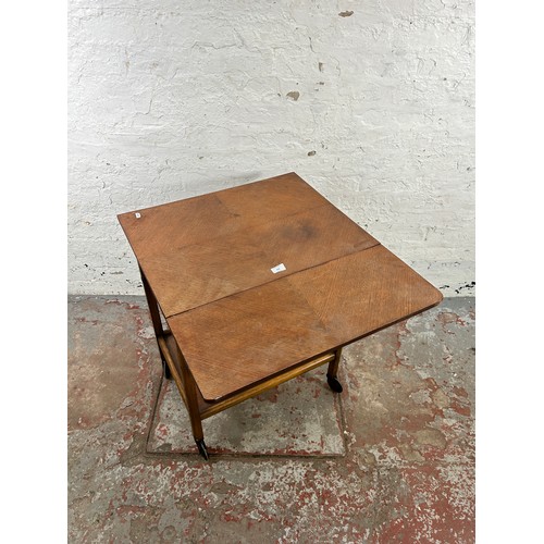 130 - A mid 20th century oak drop leaf two tier tea trolley with single drawer and castors