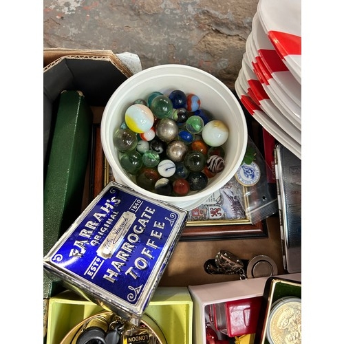 918 - A box containing post cards, diecast model vehicles, three one crown coins, vintage marbles, station... 