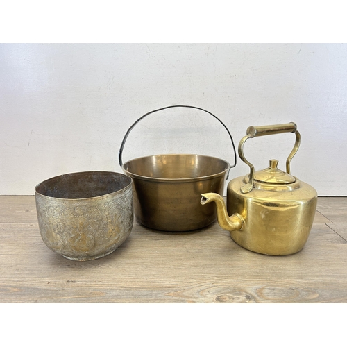 425 - Three pieces of brassware, one 19th century Middle Eastern engraved jardinière, one kettle and one p... 