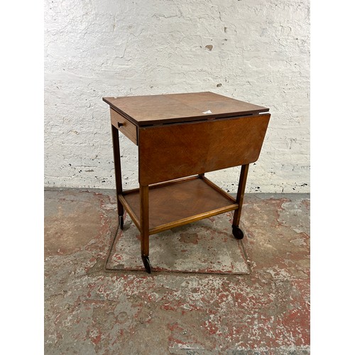 152 - A mid 20th century oak drop leaf two tier tea trolley with single drawer and castors