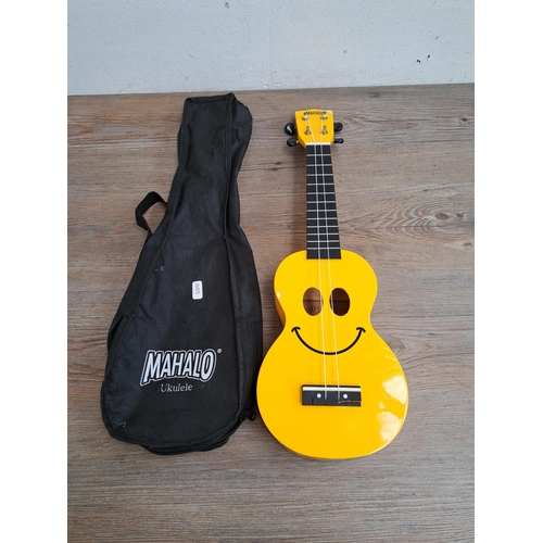 654 - Three items, one Cruiser by Crafter precision style bass guitar, one cased Mahalo yellow smiley face... 