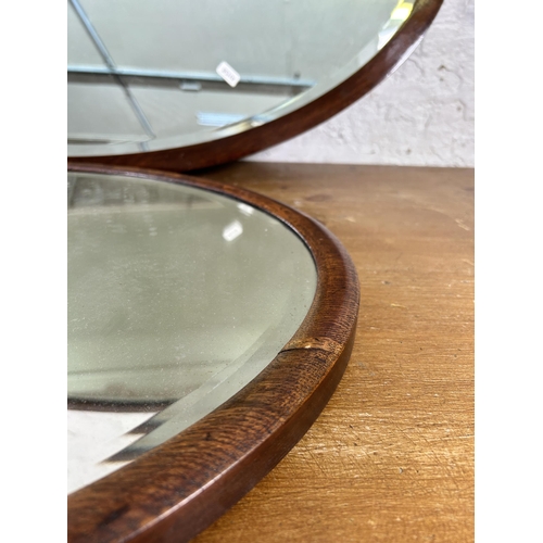 270A - Two early 20th century wooden framed bevelled edge oval wall mirrors, one oak and one mahogany