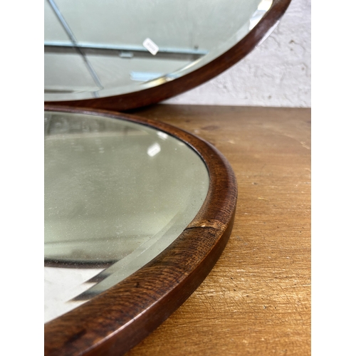 270A - Two early 20th century wooden framed bevelled edge oval wall mirrors, one oak and one mahogany