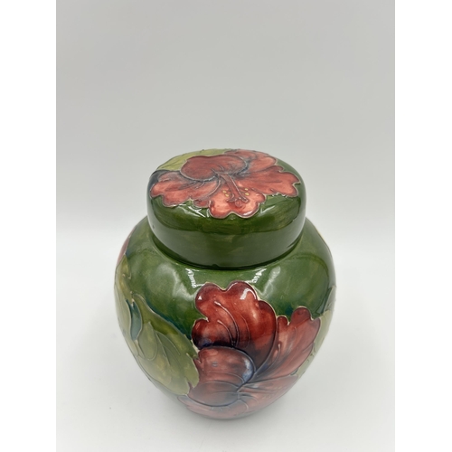 301 - A Moorcroft Hibiscus pattern ginger jar and cover - approx. 15cm high